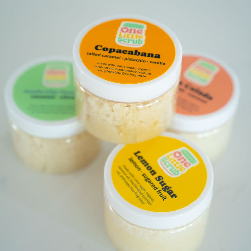 Four One Little Scrub sugar scrub jars in colorful scents